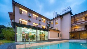 A hotel with a swimming pool, multiple balconies, and a modern architectural design. - Tianchong Yunhai Courtyard Hotel (Zhangjiajie)