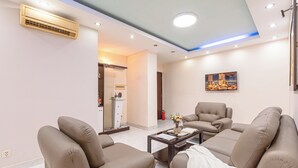 Ein modernes Wohnzimmer mit beigen Sofas, einem Couchtisch und einem Gemälde an der Wand.