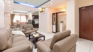 Ein modernes Wohnzimmer mit Ledersofas, einem Couchtisch und einem Essbereich mit Tisch und Stühlen.