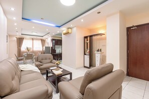 Ein modernes Wohnzimmer mit Ledersofas, einem Couchtisch und einem Essbereich mit Tisch und Stühlen.