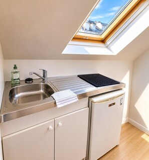 A compact kitchen with a skylight, stainless steel sink, and a compact refrigerator. - Escale Laponneraye – Proche gare & centre (Tours)
