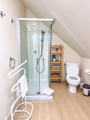 A modern bathroom with a glass-enclosed shower, a toilet, a shelf with toiletries, and a towel rack. - Escale Laponneraye – Proche gare & centre (Tours)