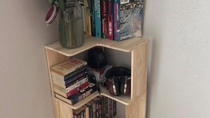 Ein Bücherregal aus Holz mit Büchern und einer Blumenvase.