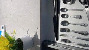 Un cajón con cubiertos, un cuchillo y una cuchara.