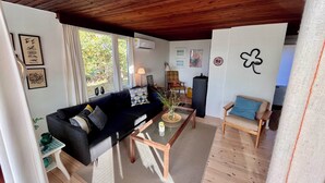 A living room with a sofa, a coffee table, a chair, a lamp, and a wall with a four-leaf clover decoration.