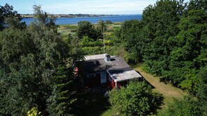 A house surrounded by dense forest with a view of a lake. - 2 bedroom accommodation in Millinge (Millinge)
