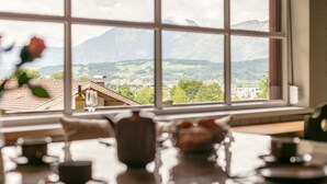 Ein Zimmer mit großem Fenster und Blick auf eine Berglandschaft.