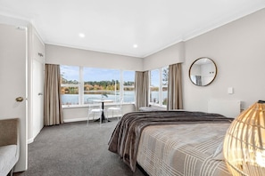 Ein Hotelzimmer mit Bett, Schreibtisch und Seeblick.