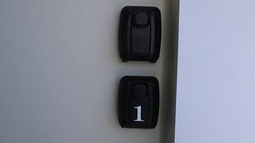Deux objets noirs sur un mur, dont l’un porte le chiffre « 1 » en blanc.