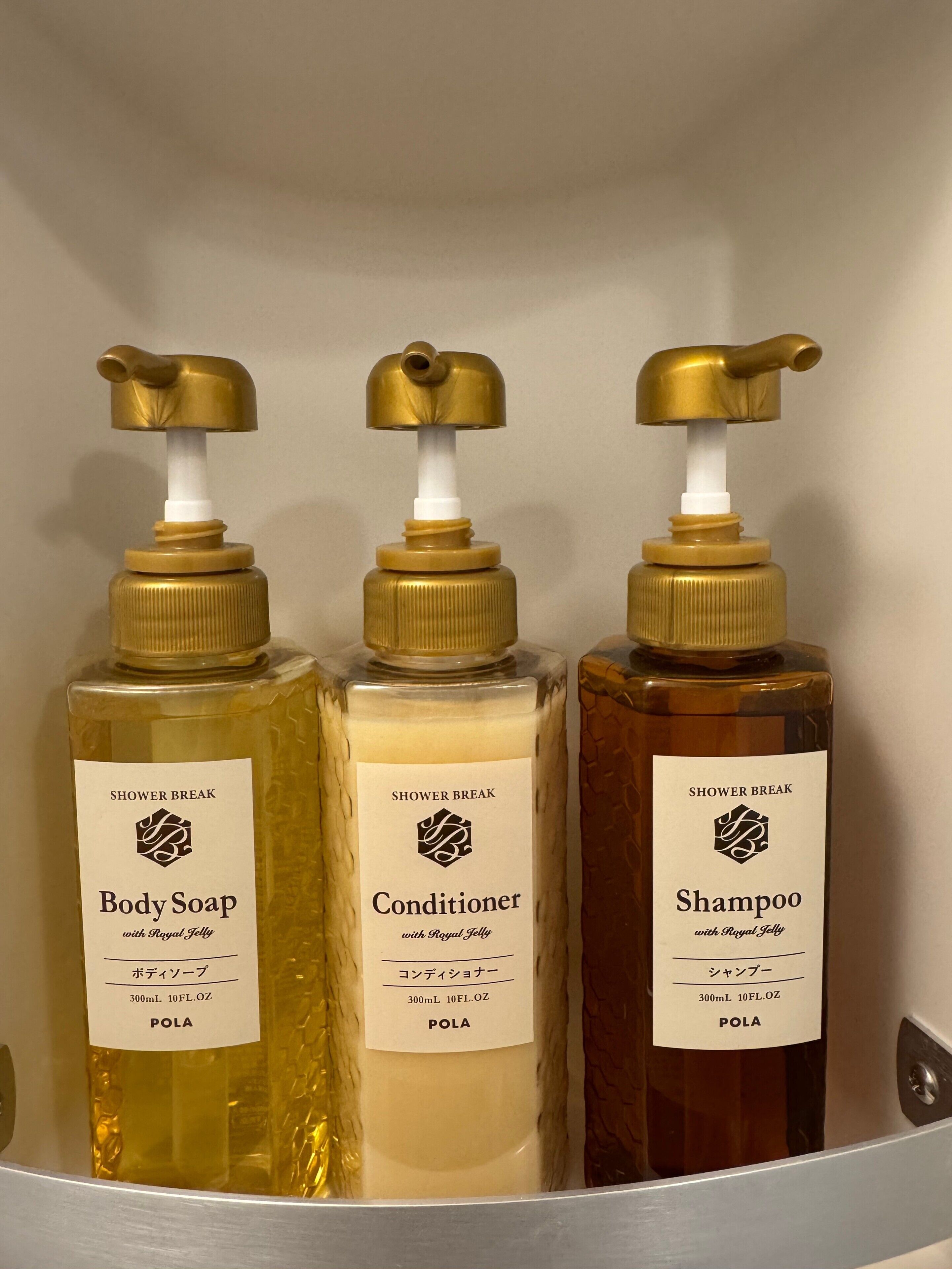 Three bottles of shower break products in a metal container.