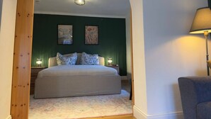 A bedroom with a bed, two bedside tables, and a lamp. - The Forest Green Residence – Garden & Tranquility (Oldenburg)