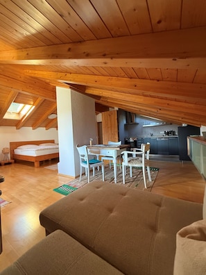 Ein Zimmer im Loft-Stil mit Essbereich, Küche und einem Bett.