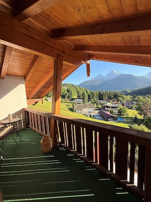 Ein Holzbalkon mit Blick auf eine Berglandschaft.