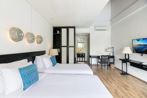 A hotel room with a large bed, a desk, a chair, and a TV. - Serenity Villa Nusa Dua (Badung)