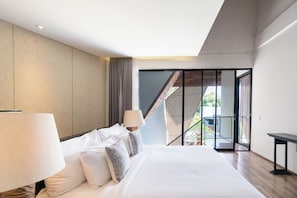 A modern hotel room with a large bed, a balcony with a view, and a sliding glass door. - Serenity Villa Nusa Dua (Badung)