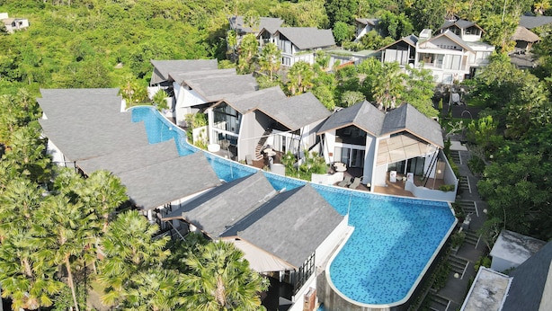 A resort with multiple houses, a large swimming pool, and lush greenery. - Serenity Villa Nusa Dua (Badung)