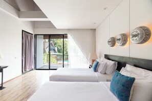 Habitación de hotel con dos camas, un ventanal grande y vistas al exterior.