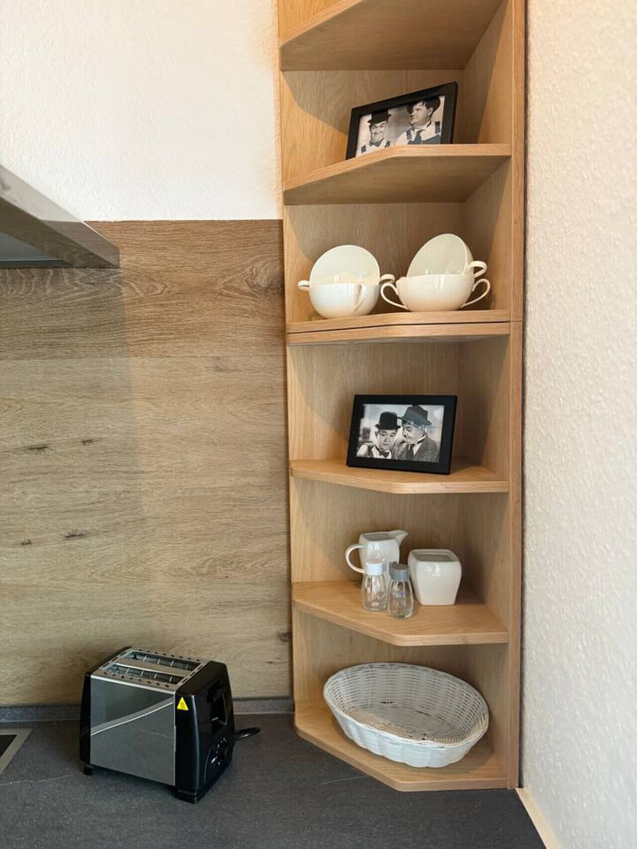 A corner shelf with a toaster, a framed photo, and various kitchen items.