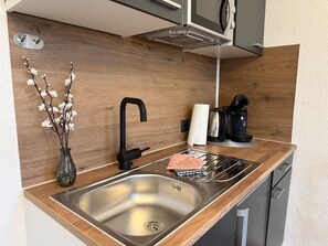 Kylskåp, mikrovågsugn, kaffe- och tebryggare och matbord