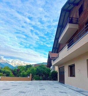 Ein modernes Gebäude mit flachem Dach, einer Garage und Blick auf Berge.