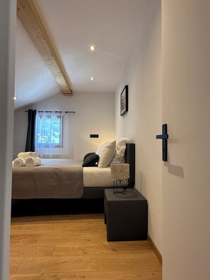 Ein Schlafzimmer mit Bett, Nachttisch und einem fenster mit Vorhängen.