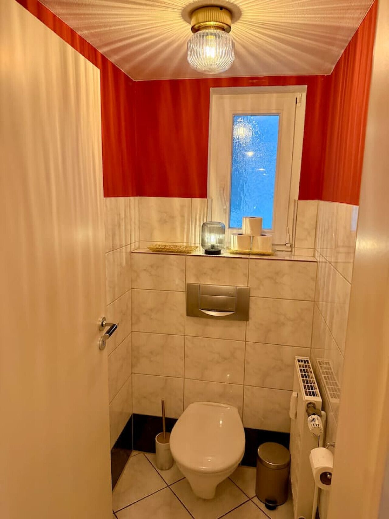 Un bagno compatto con toilette, bidet e una piccola finestra.