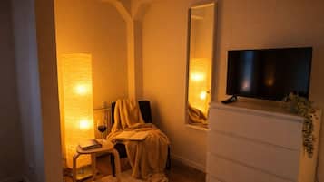 Una stanza con un letto, una televisione su un comò e una finestra con vista.