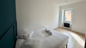 Ein Schlafzimmer mit Bett, Kissen und einem Fenster.