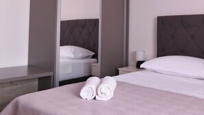 A hotel room with a bed, a nightstand, a wardrobe, and a mirror. - Stunning Seaside Villa PIA First Floor (Okrug Gornji)