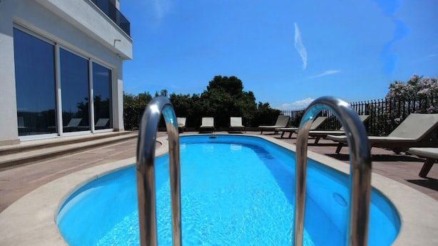 A swimming pool with metal railings, lounge chairs, and a building with large windows. - Stunning Seaside Villa PIA First Floor (Okrug Gornji)