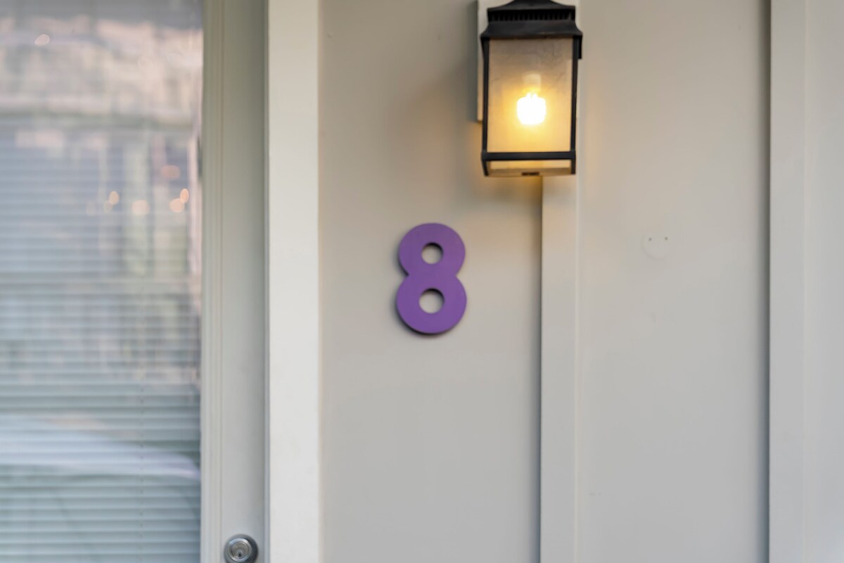 A door with a number '8' and a wall-mounted light fixture.