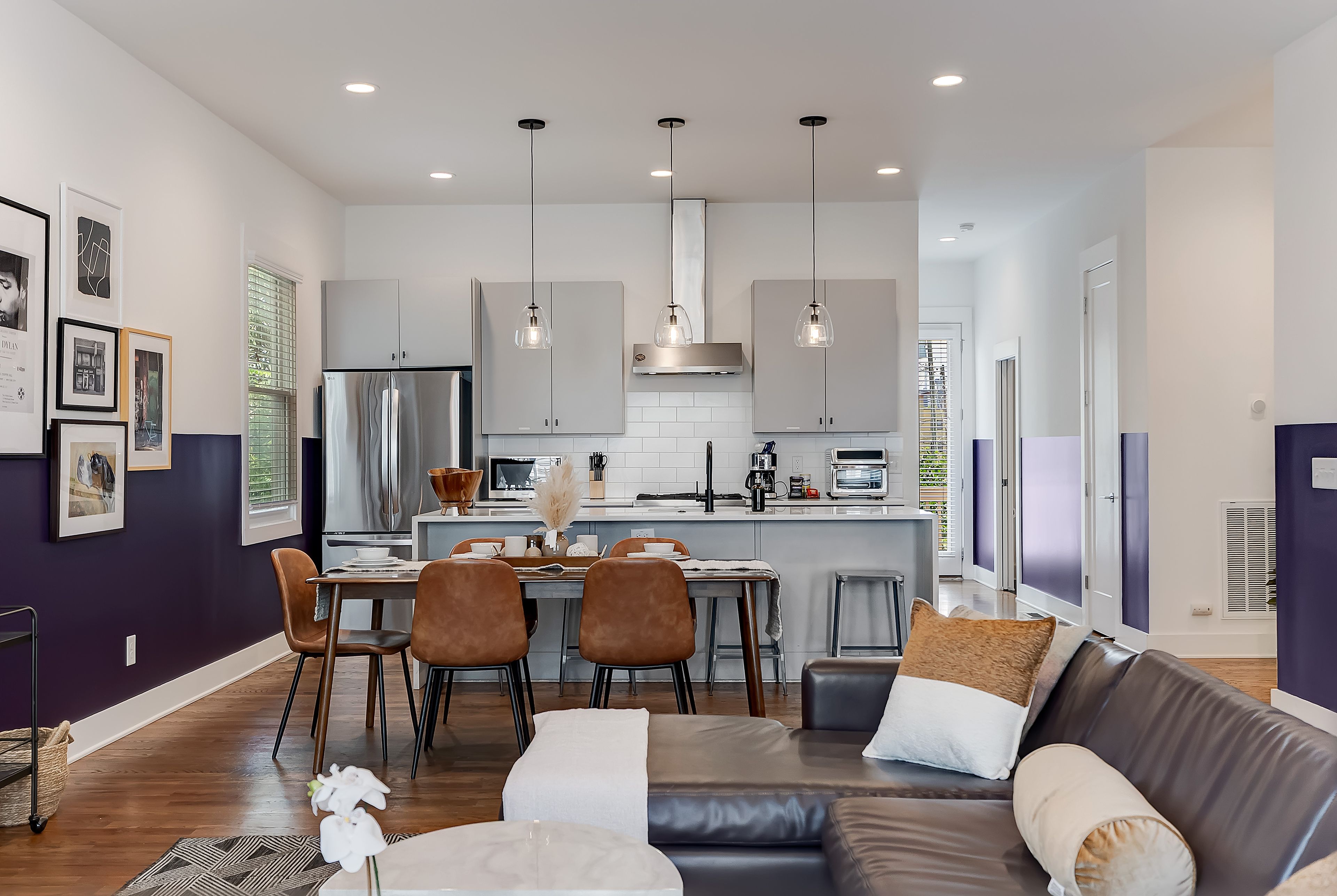 A modern kitchen with a dining area, a sofa, and a coffee table.