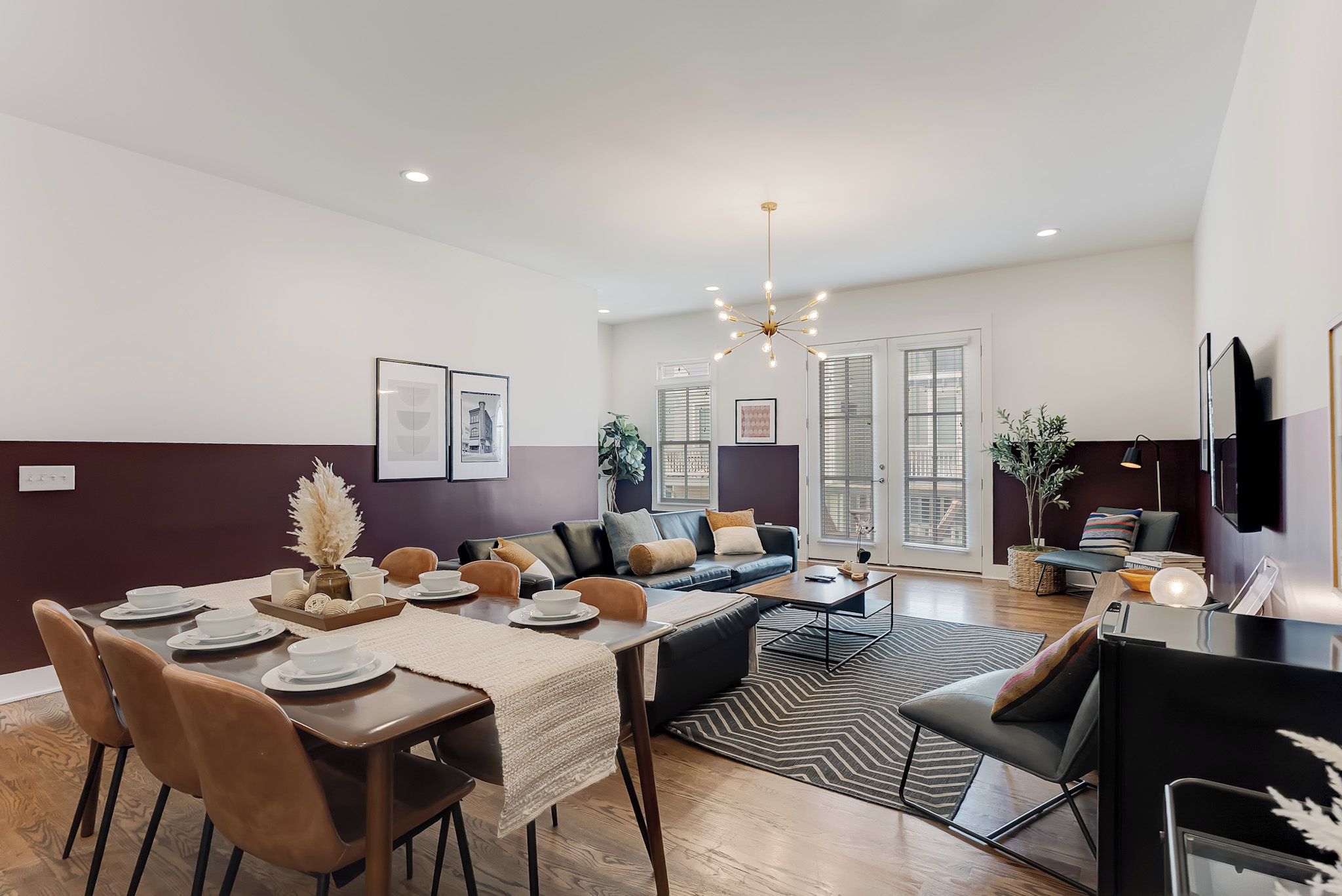 Una sala de estar moderna con comedor, que incluye un conjunto de sofá, una mesa de centro y una mesa de comedor con sillas.