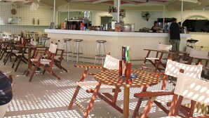 Un restaurante con terraza, bar y mostrador con diversos productos.