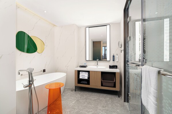A modern bathroom with a bathtub, a sink, a mirror, and a glass shower enclosure. - Hampton by Hilton Tianjin Baodi (Tianjin)