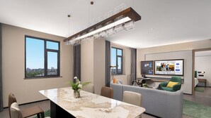 A modern hotel room with a marble dining table, a sofa, a TV, and large windows. - Hampton by Hilton Tianjin Baodi (Tianjin)