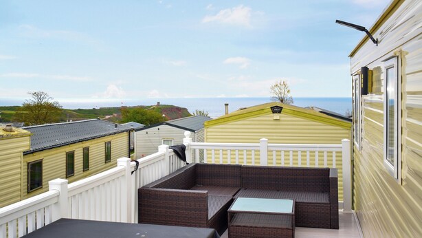 Eine Terrasse mit Tisch und Sitzgelegenheiten mit Blick auf eine schöne Aussicht.
