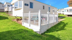 A white mobile home with a fenced deck, a small porch, and a sign that reads 'The Horizon.' - 2 bedroom accommodation in Exmouth (Exmouth)