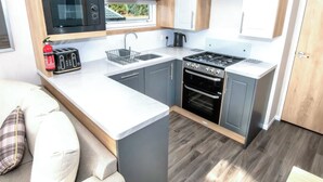 Une cuisine compacte équipée d’un four à micro-ondes, d’un grille-pain, d’un évier, d’une cuisinière et d’un four.