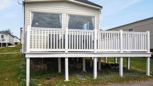 A mobile home with a balcony, a TV antenna, and a logo on the roof. - Juniper Close 52 - UKC9405 (Exmouth)