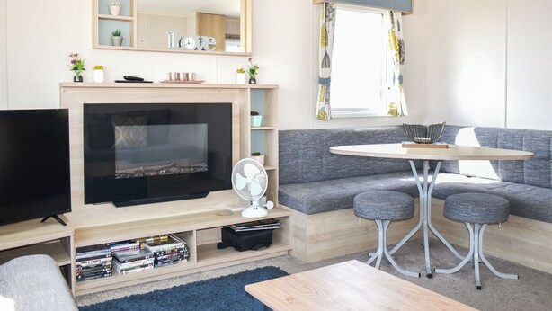 Un salon avec un téléviseur, un canapé, une table basse et une cheminée.