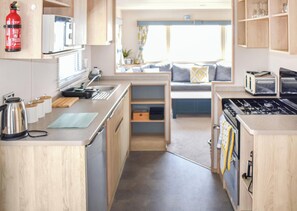 A compact kitchen with a microwave, kettle, and toaster. - Karo Place 113 - UKC9404 (Exmouth)