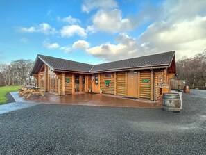 A log cabin-style building with a covered patio and picnic tables. - Bellstane Chalet - UKC9440 (Glasgow)