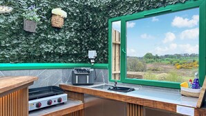 Una cocina compacta con estufa a gas, tostadora y pileta.