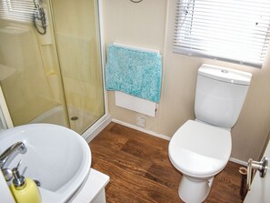 Ein Badezimmer mit Dusche, Toilette und Waschbecken.