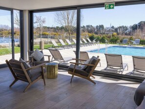 A poolside area with lounge chairs, a wicker basket, and a view of the pool and surrounding greenery. - 3 bedroom accommodation in Dorchester (Dorchester)
