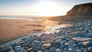 A rocky beach with a cliff and the ocean in the background. - 2 bedroom accommodation in Cardiff (Cardiff)