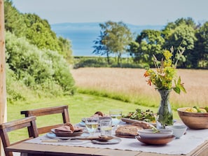 A table set outdoors with a view of a field and trees. - 2 bedroom accommodation in Cardiff (Cardiff)