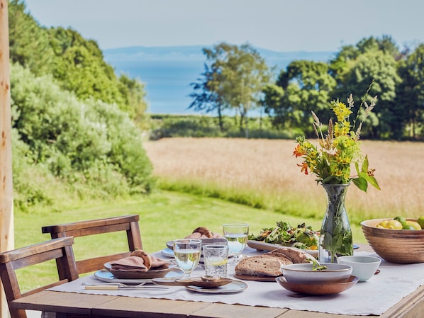 Mesa al aire libre con vista a un campo y árboles.