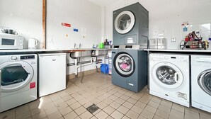 A laundry room with multiple washing machines, a microwave, and a coffee maker. - Relax in our stunning seaside glamping pods in Peterhead. (Banff)